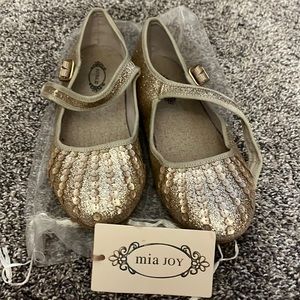 A pair of Mia Joy shoes. Size youth 3 with a shiny gold color